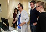 Chefarzt Dr. Kothe erkl&auml;rt Sch&uuml;lern das Trainingsger&auml;t (Foto: Helios Klinik)