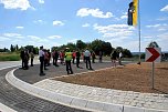 Gro&szlig;er Bahnhof zur &Uuml;bergabeveranstaltung. Die zur H&auml;lfte asphaltierte Insel des neuen Kreisverkehrs am Th&auml;lmannschacht bietet immerhin Platz f&uuml;r viele Menschen und eine Fahne. (Foto: J. Miche)