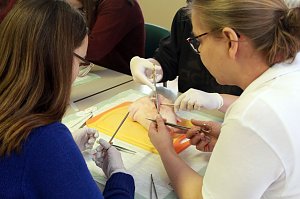 Schüler probieren unter Anleitung eine richtige Naht zu setzen