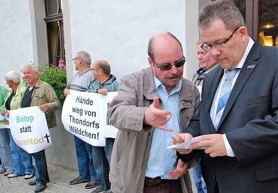 Pro Baum-Chef Peter Frobel (l.) und AfD-Landkreis-Chef und MdL Jens Diederichs diskutieren die Forderungen der Umweltfreunde, die auf einem Faltblatt formuliert sind. (Foto: Jochen Miche)