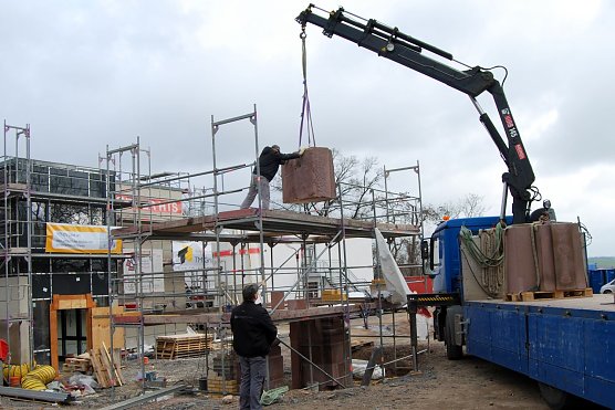 Behutsam hebt der Kran ein Teilst&uuml;ck des historischen Portals vom Lkw und f&uuml;gt es zu dem bereits platzierten St&uuml;ck. (Foto: Gabriele Lakomy)
