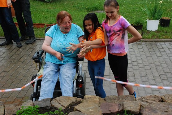 Es ist vollbracht: Der Kr&auml;utergarten ist seiner Bestimmung &uuml;bergeben. Assistiert von zwei Sch&uuml;lerinnen der Riestedter Freien Grundschule durchschnitt Heimbeiratsvorsitzende Christel Fabian, die in der Einrichtung "B&uuml;rgermeisterin" genannt wird, das Er&ouml;ffnungsband. (Foto: Jochen Miche)