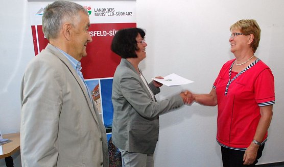 Heide B&ouml;land (rechts) empf&auml;ngt f&uuml;r ihre Selbsthilfegruppe Multiple Sklerose aus Sangerhausen von Landr&auml;tin Dr. Angelika Klein einen Spendenscheck. Der Hauptorganisator der Benefizgala und mit begeistertem Applaus belohnte Mitgestalter G&ouml;tz Schneega&szlig; gratulierte. (Foto: Jochen Miche)