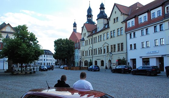 Zwei verhinderte Spazierg&auml;nger betrachten, ans Auto gelehnt, den menschenleeren Markt. Der zehnte Hettstedter Spaziergang fiel, wie schon der achte und neunte, aus. Stilles Ende einer kleinen Revolte. (Foto: J. Miche)