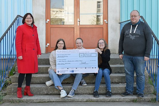 Bildunterschrift: IHK Gesch&auml;ftsf&uuml;hrerin Dr. Simone Danek (l.) &uuml;bergab den Scheck an die Sankt Mauritius-Sekundarschule in Halle (Saale). Mit dem stellvertretenden Schulleiter Steffen Thurm freuen sich die Sch&uuml;lerinnen, Isabell, Maria und Alma Thekla.  (Foto: Foto: IHK Halle-Dessau/Markus Scholz)