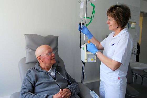 Bild: Dr. Astrid M&uuml;ller kontrolliert die Infusion bei Rainer Peters.