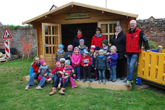Bild: Gl&uuml;ckliche Kinder und Erwachsene vor dem "Haus der Entdecker". Im Hintergrund stehend (v.l.): Scheck&uuml;berbringerin Elfie Schubert, Kita-Leiterin Anke Rabenhold, Oberb&uuml;rgermeisterin Jutta Fischer und Ortsb&uuml;rgermeister J&uuml;rgen Grobe.