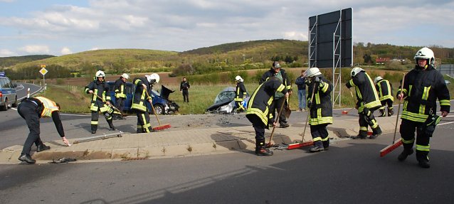 Bild: W&auml;hrend die Feuerwehrleute aus Riestedt und Gonna wieder f&uuml;r saubere und sichere Fahrbahnen sorgen, markiert ein Polizist (links) die "Flugbahn" des Unfallverursacherfahrzeugs.