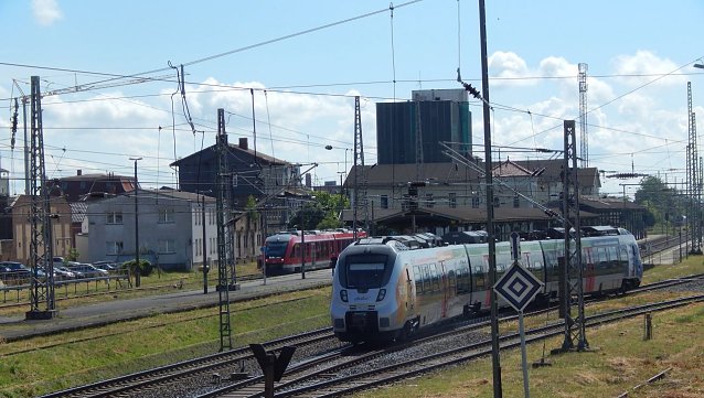 Bild: Ein Zug f&auml;hrt aus dem Bahnhof aus. Man sieht sehr viele Gleise und ein Bahnhofsgeb&auml;ude. 