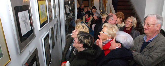 In Scharen schoben sich die Besucher an den Bilderw&auml;nden mit Werken der K&uuml;nstlerin Ramona Hollunder entlang. Da hatten es Menschen wie der Eisleber Fotok&uuml;nstler Richard Bartlitz (rechts im Bild), der die meisten Besucher um einen Kopf &uuml;berragte, leichter, einen Blick auf die Galerie zu werfen. (Foto: Jochen Miche)