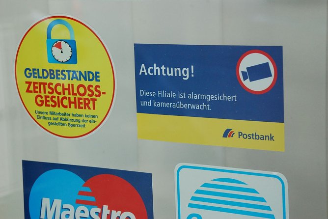 Warnungen an der T&uuml;r, welche die "richtigen" Verbrecher nicht abschrecken. Sie kommen auf verbrecherische Weise dennoch an das Geld. (Foto: Jochen Miche)