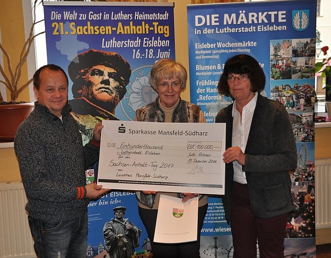 Scheck&uuml;bergabe durch die Landr&auml;tin (rechts) an Oberb&uuml;rgermeisterin Jutta Fischer (Mitte) und Org.-Leiter Siegmund Michalski. (Foto: Stadtverwaltung Eisleben)