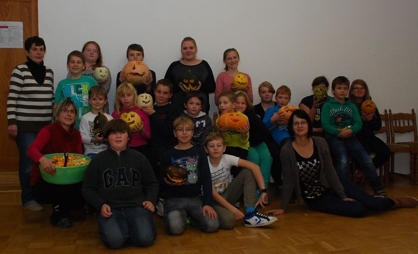 Gruppenbild mit Schnitzkunstwerken. Viel Zeit, noch mehr Nerven und ganz viel liebevolle F&uuml;rsorge brachten Cordula Franke (links stehend), Anke Weder (links hockend) und Nadine Schmei&szlig;er (rechts sitzend) bei der Betreuung der 15 temperamentvollen &Uuml;bernachtungsg&auml;ste auf.
