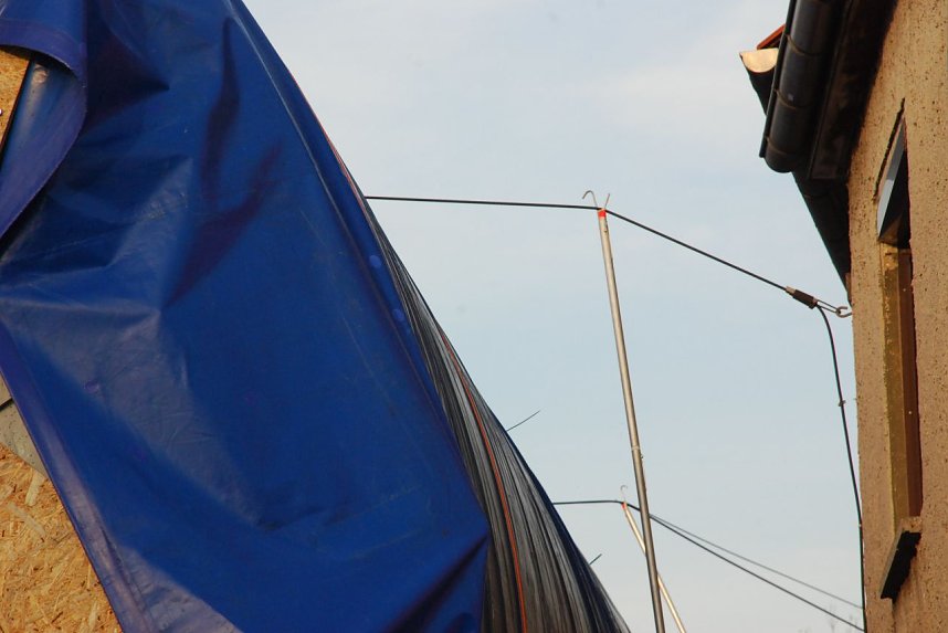 Mittels langer Stangen, an denen sich teilweise Haken befanden, mussten die in gut sechs Meter H&ouml;he befindlichen Telefonleitungen nochmals angehoben werden.