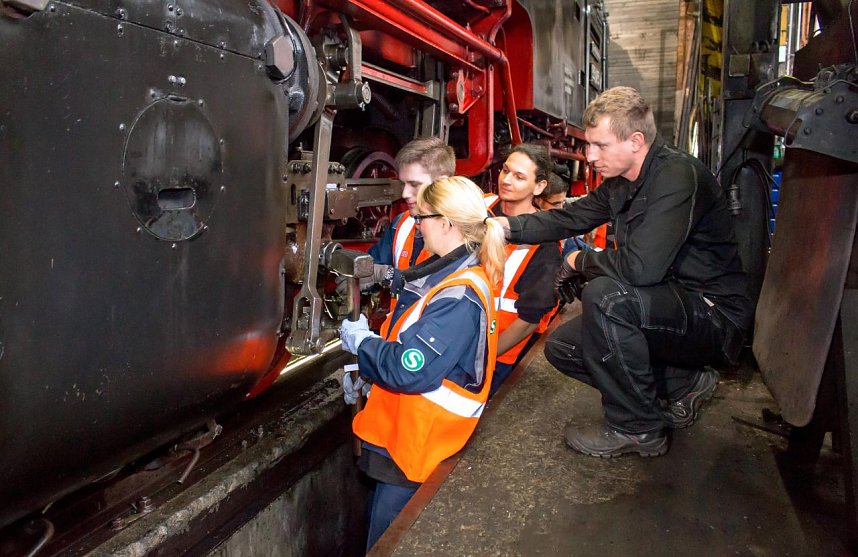 Anleitung vom HSB-Profi: Jean-Pierre H&uuml;bner (rechts) erkl&auml;rt den Auszubildenden der S-Bahn Berlin die Reparatur am Fahrwerk einer sechzig Jahre alten Brockenlok.